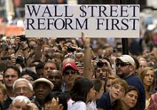 En mand holder et skilt op foran The Federal Hall i New York efter præsident Obama har holdt sin store tale om finanskrisen den 14. september 2009.