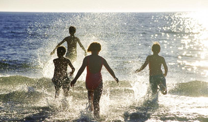 børn løber ud i havet