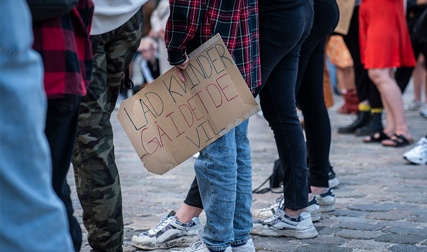 Papskilt med teksten "Lad kvinder gå i det de vil". Fra demonstration imod EU-dom om tørklædeforbud i 2021.